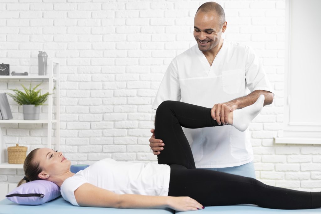 A clinical therapist at Joint Health Solutions performing manual joint mobilization and guided corrective exercise for a patient with knee osteoarthritis.