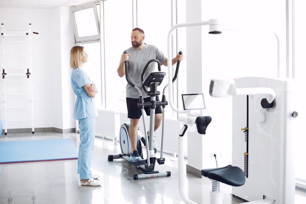 A clinical specialist at Joint Health Solutions performing a digital gait analysis and real-time posture correction for a patient with hip and knee arthritis.