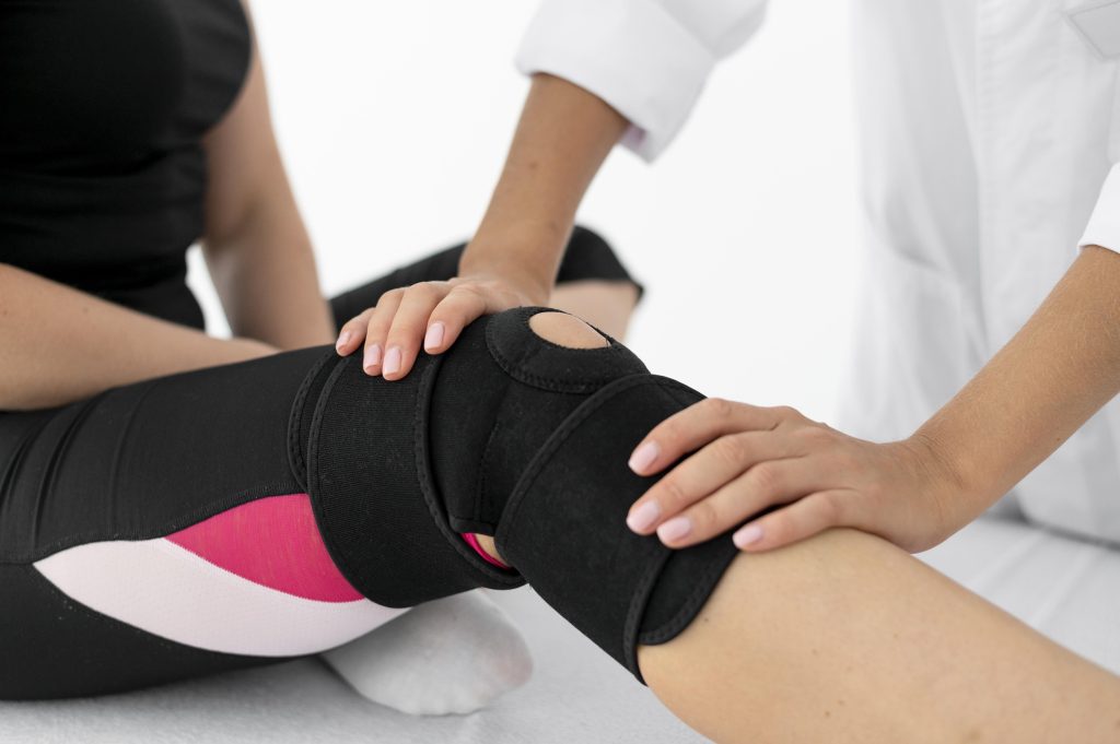 A medical professional at Joint Health Solutions fitting a patient with a custom offloading knee brace designed to shift pressure away from damaged joint cartilage.