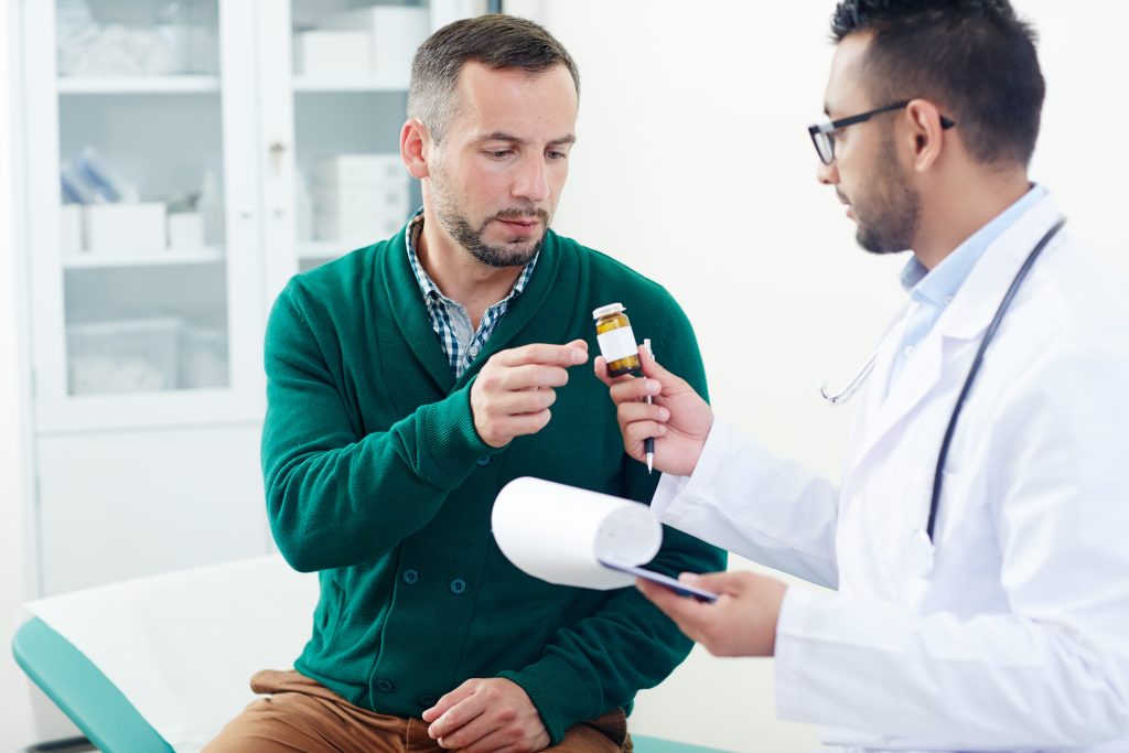 A medical professional in white clinical gloves administering an image-guided joint injection to a patient’s facial or joint area.