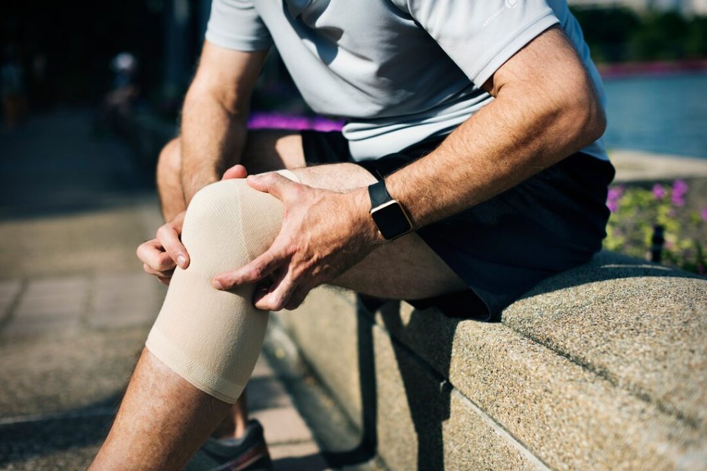 Patient wearing offloading knee brace for arthritis support