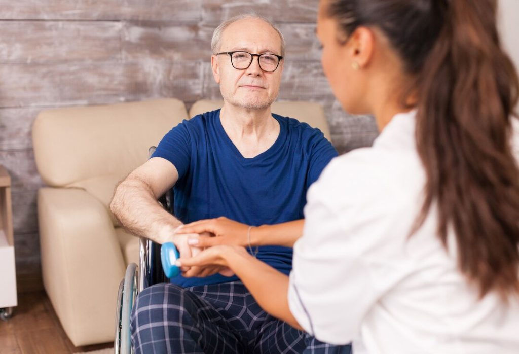 Healthcare professional greeting an older patient during a clinic consultation