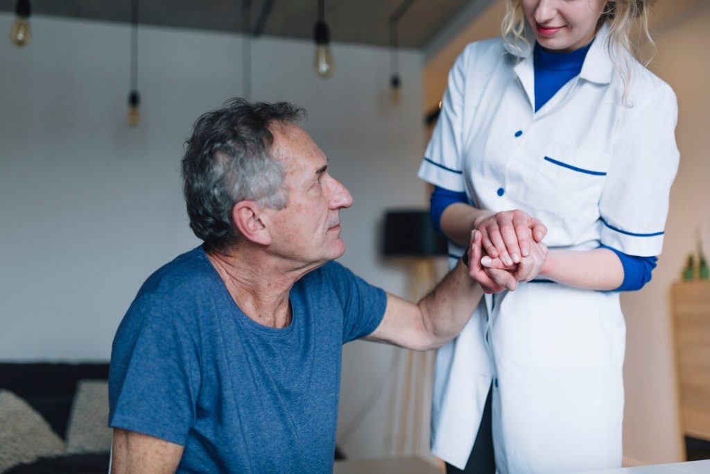 Healthcare professional greeting an older patient during a clinic consultation