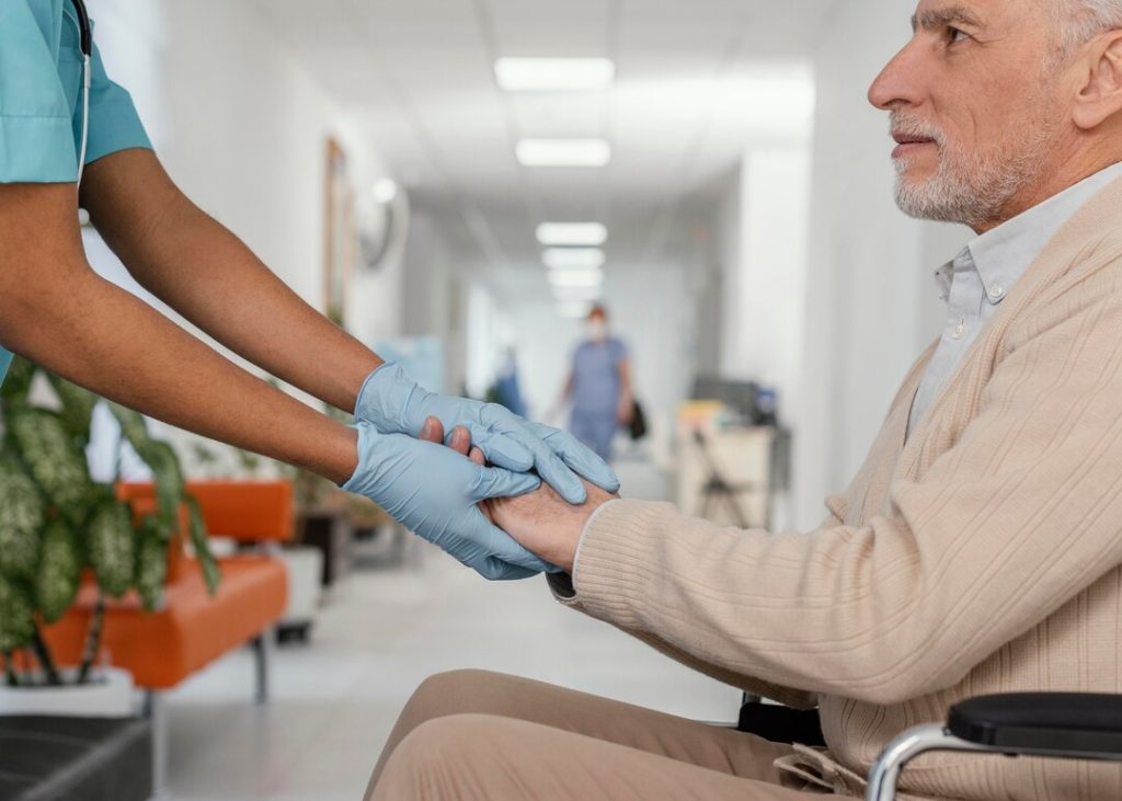 Healthcare professional greeting an older patient during a clinic visit