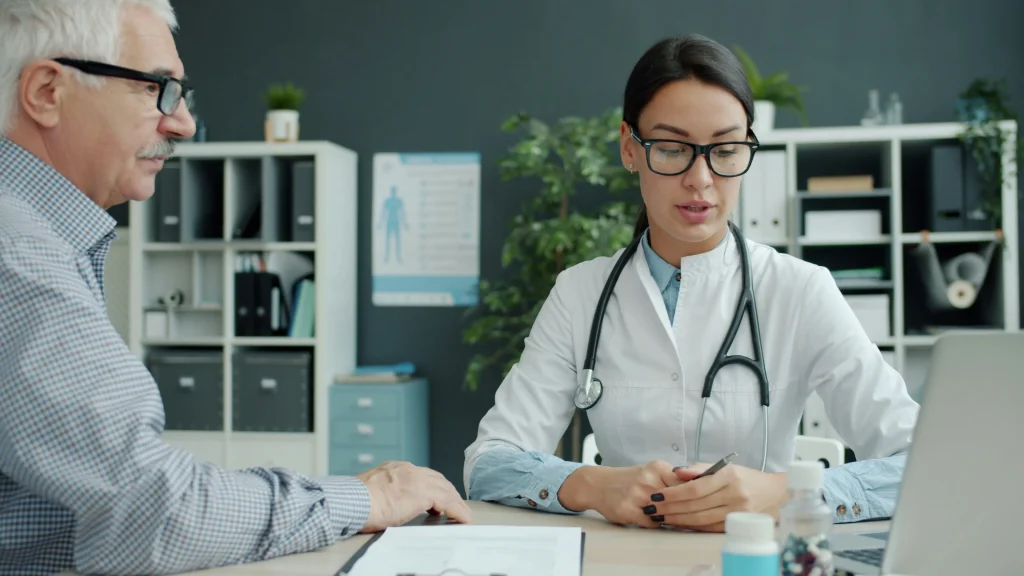 Healthcare professional greeting an older patient during a clinic consultation