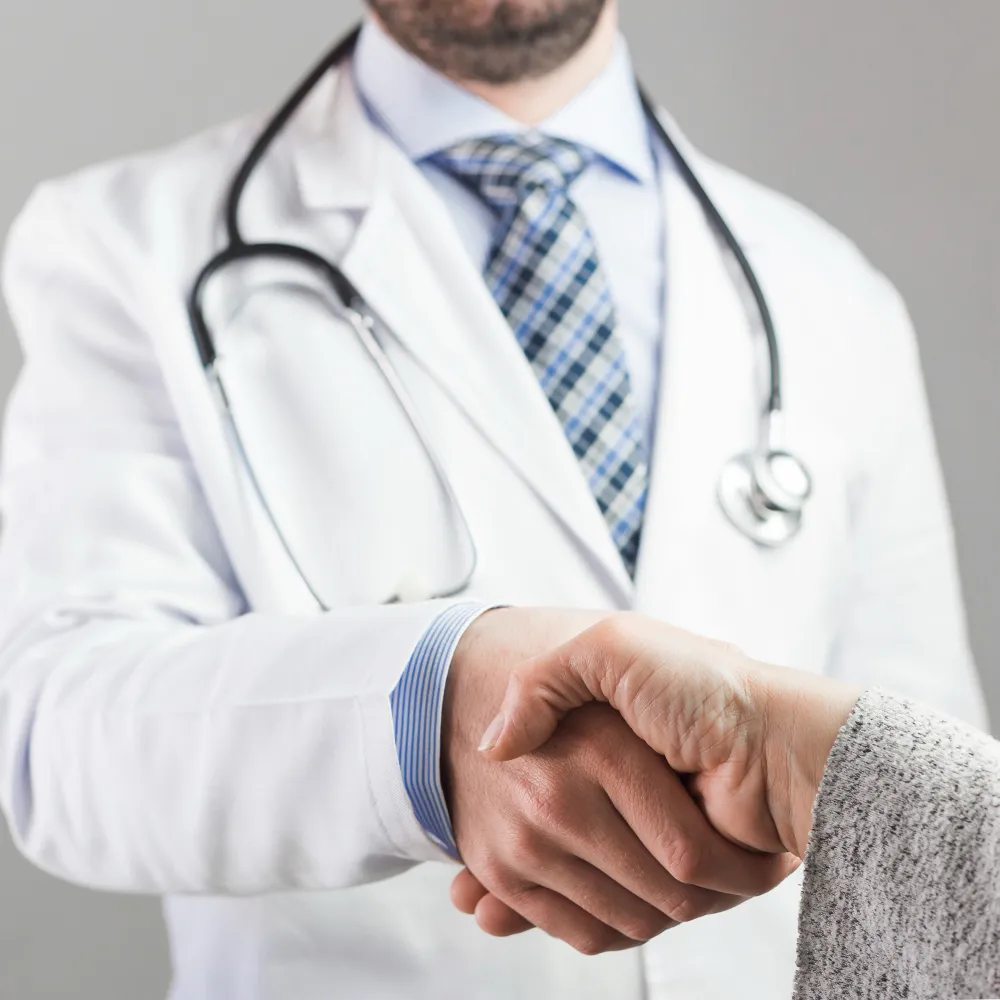 Healthcare professional greeting an older patient during a clinic visit